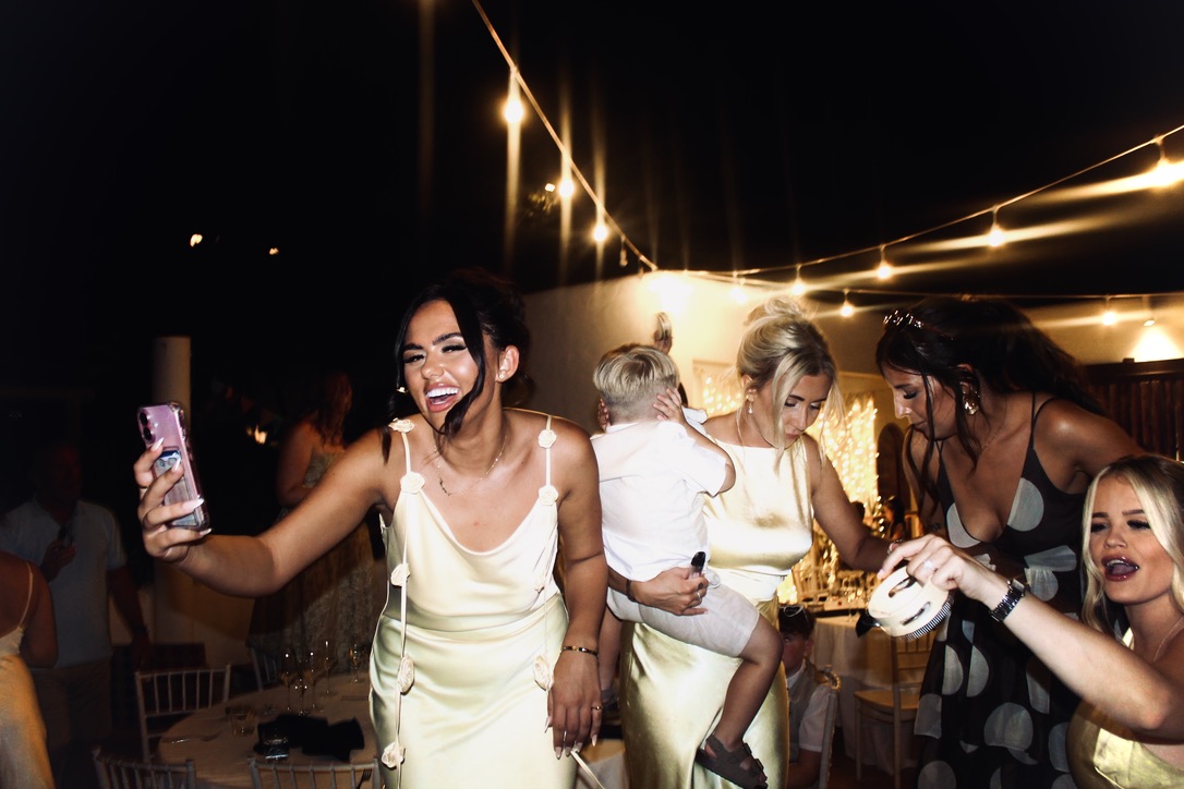 Friends celebrating beneath golden string lights